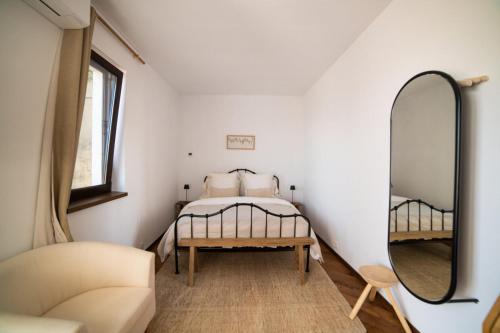 a small bedroom with a bed and a mirror at Domeniul Drăgași 