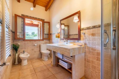 a bathroom with a sink and a toilet and a mirror at Maravillosa finca con piscina in Marratxi