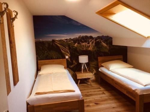 - 2 lits dans une chambre ornée d'une peinture murale dans l'établissement Ferienwohnung Tanneberger, à Oberstdorf