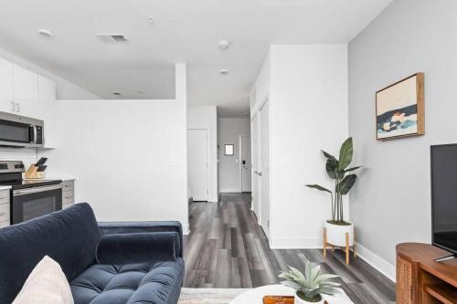 a living room with a blue couch and a table at Mid-Century Modern Studio CozySuites Downtown in Indianapolis