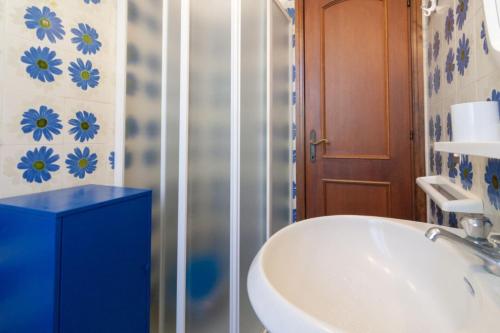 een badkamer met een witte wastafel en een blauwe kast bij Appartamento CORSICA in Follonica
