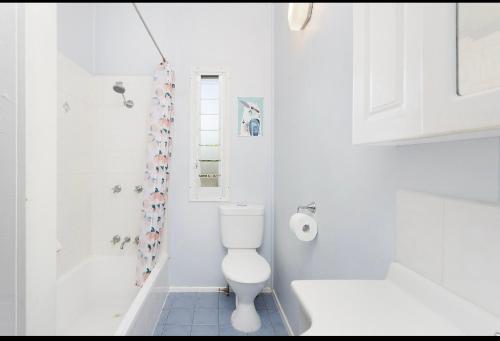 ein weißes Bad mit einem WC und einer Dusche in der Unterkunft Jardine Street in Rockhampton