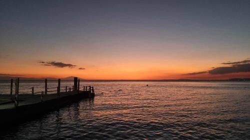 a sunset over a body of water with a dock at Dive and Trek Resort and Marine Sanctuary in Bauan
