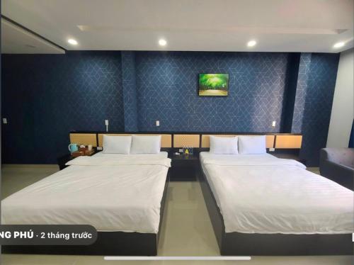 two beds in a room with blue walls at Hưng Phú Hotel HCM in Ho Chi Minh City