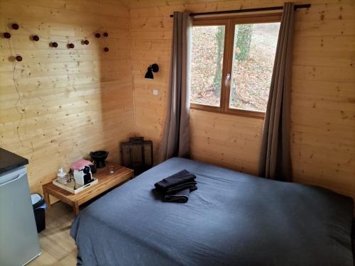 Cahuzac-sur-VèreにあるLes lodges d'Adelaideの木製の部屋にベッド1台が備わるベッドルーム1室があります。