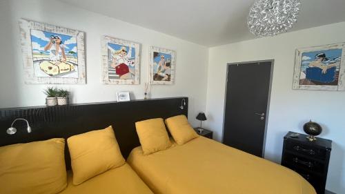 a bedroom with a yellow bed and posters on the wall at Domaine Georges V in Saint-Junien