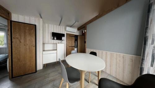 a dining room with a white table and chairs at Mobilhome tout confort in La Teste-de-Buch