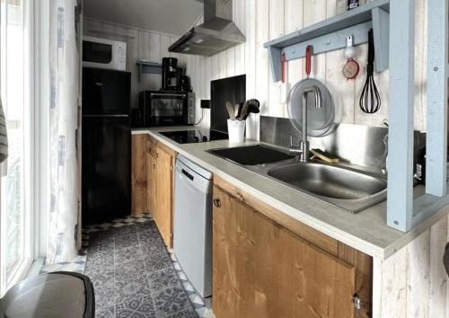 a kitchen with a sink and a refrigerator at Mobilhome tout confort in La Teste-de-Buch