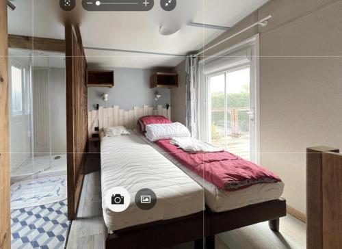 a bed in a room with a glass wall at Mobilhome tout confort in La Teste-de-Buch