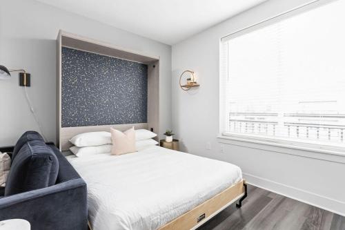 印第安納波利斯的住宿－Modern CozySuites Studio Apartment，一间卧室设有一张床和一个大窗户