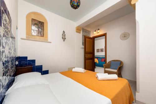 una camera da letto con un letto e una sedia di Appartamenti Le Maioliche a San Vito lo Capo
