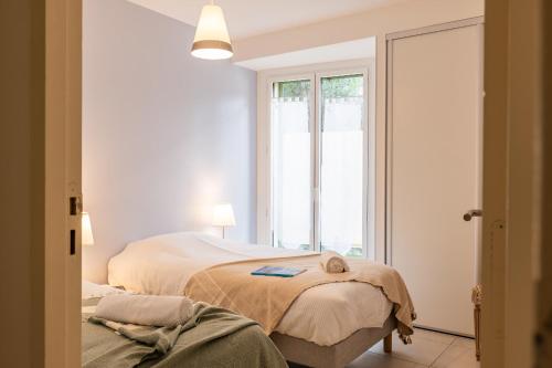 a bedroom with two beds and a window at Palm Beach - swimming pool - beach at few steps in Cannes