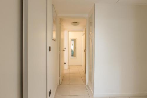 - un couloir avec des murs blancs et du carrelage blanc dans l'établissement Palm Beach - swimming pool - beach at few steps, à Cannes
