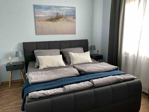 ein Bett mit Kissen darauf im Schlafzimmer in der Unterkunft discovAIR Graal Müritz -Haus Quisisana- Strandnah mit Netflix in Graal-Müritz