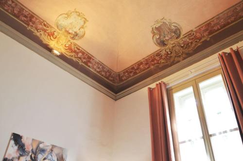 a room with a coffered ceiling and a window at Casa Del Teatro in Pavia