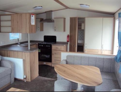 a kitchen with a couch and a table in a room at Holiday Escapes in Selsey