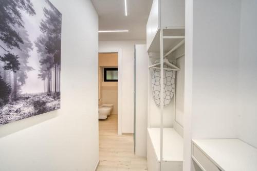 un pasillo con paredes blancas y una pintura en la pared en Apartment Suzzani 273 - Interno A2, en Milán
