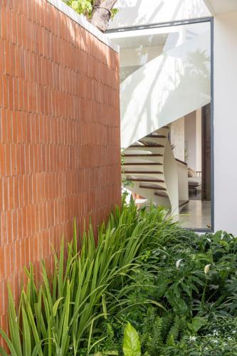 a brick wall with a staircase and plants at Nhãn Stay in Hue
