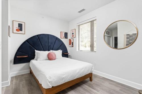 a bedroom with a large bed and a mirror at CozySuites Modern Studio steps from Broad Ripple in Indianapolis