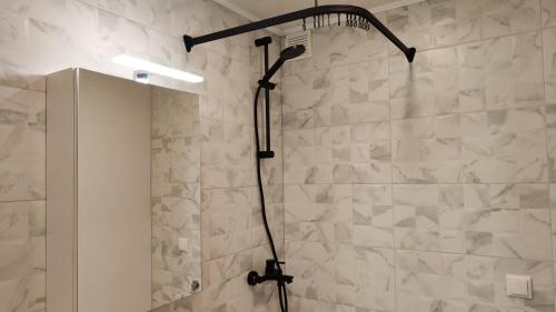 um chuveiro com uma cabeça de chuveiro preta na casa de banho em Võhma industriaal pesa 