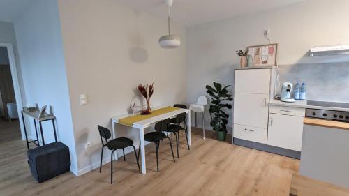 een keuken met een tafel en stoelen en een koelkast bij Inheidener Neubau Ferienwohnung in Hungen