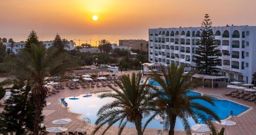 a view of a resort with a pool and palm trees at El Mouradi Palace- Couple et Famille uniquement in Port El Kantaoui