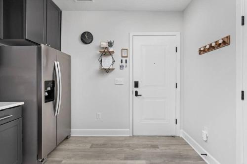 a kitchen with a refrigerator and a white door at CozySuites Modern Studio in Meridian Kessler in Indianapolis