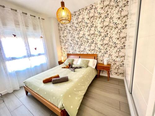 een slaapkamer met een bed met bloemenbehang bij TODIMER Apartamento lujo in Motril