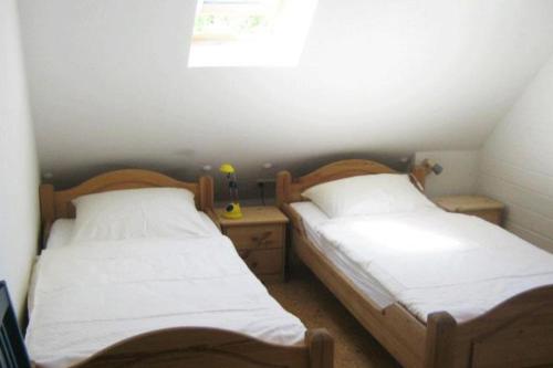two twin beds in a small room with a window at Deetje in Borkum