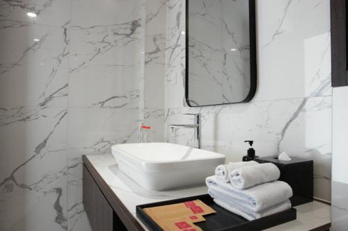 bagno con lavandino bianco e specchio di ValStar Hotel Canggu a Canggu