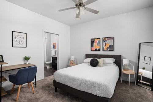 a bedroom with a bed and a desk and a ceiling fan at Cozysuites Spacious 2BR next to Whole Foods in Indianapolis