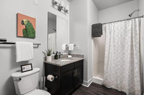 ein Bad mit einem WC und einem Duschvorhang in der Unterkunft Cozysuites Spacious 2BR next to Whole Foods in Indianapolis