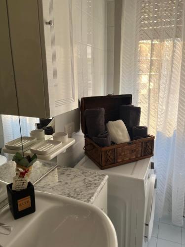 - Baño con lavabo y cesta de toallas en Appartamento Dante, en Seregno