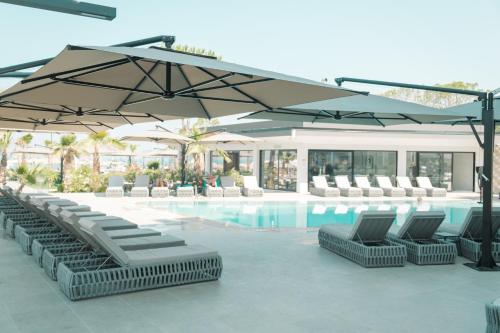 a swimming pool with lounge chairs and an umbrella at Comfort Suites in Golem