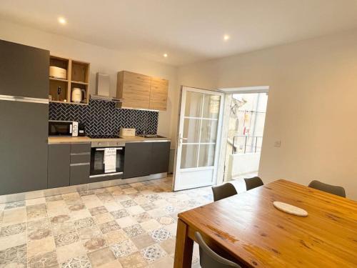 une cuisine avec une table en bois et une salle à manger dans l'établissement Maison l’Oustaou Cornillonnais, à Cornillon-Confoux