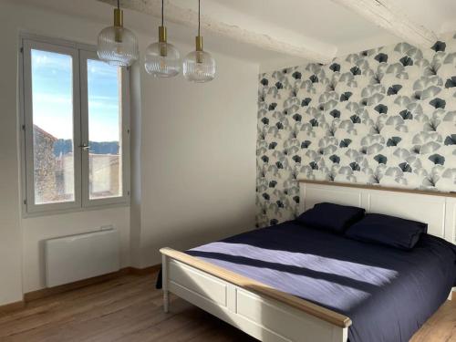una camera da letto con un letto e una finestra di Maison l’Oustaou Cornillonnais a Cornillon-Confoux