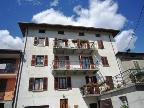a tall white building with windows and balconies at Casa Giuliana in Teglio