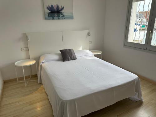 sypialnia z białym łóżkiem z czarną poduszką w obiekcie Agi Cap Llarg w mieście Roses