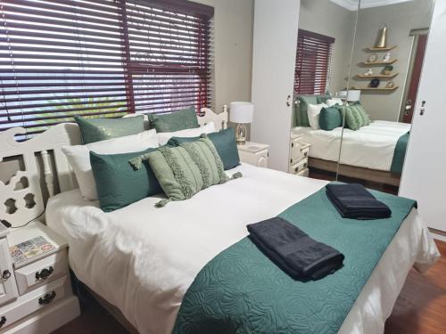 a bedroom with two beds with green and white at Urban Oasis Cape Town in Cape Town