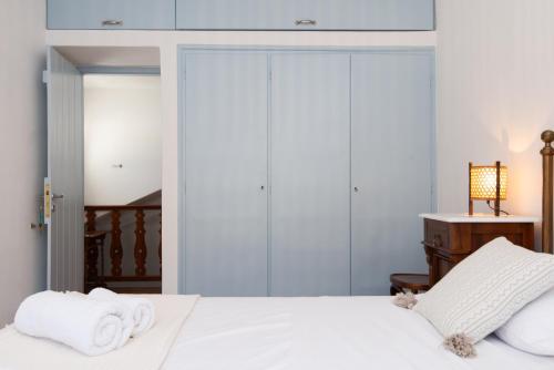 a bedroom with a bed with white sheets and towels at Stunning Sunset House on Kamares Bay with Playground in Kamarai