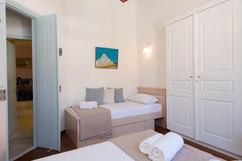 a small bedroom with a bed and a closet at Stunning Sunset House on Kamares Bay with Playground in Kamarai