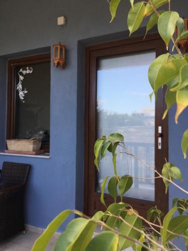 uma porta com uma janela e uma planta na frente dela em happyWish Syros em Ermoupoli
