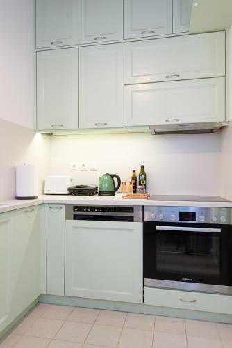 a kitchen with white cabinets and a stove top oven at Stunning Sunset House on Kamares Bay with Playground in Kamarai