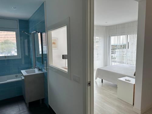 een badkamer met een bed, een wastafel en een spiegel bij Agi Cap Llarg in Roses