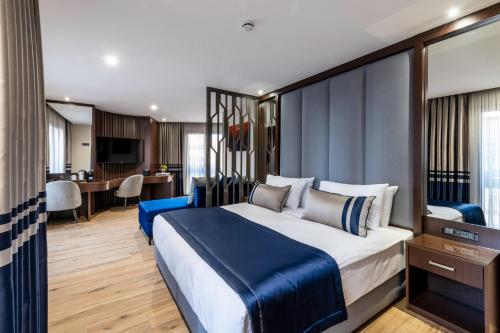 a bedroom with a large bed and a desk at Aprilis Deluxe Hotel in Istanbul