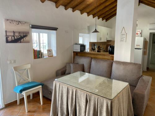 ein Wohnzimmer mit einem Tisch und einem Sofa in der Unterkunft Casa Juan Harina in Setenil de las Bodegas
