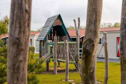 a playground with a slide in a yard at Strandcamping Valkenisse in Biggekerke