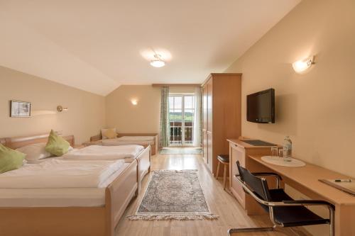 Kopplにあるホテル　ガストホフ　アム　リードルのベッド2台とデスクが備わるホテルルームです。