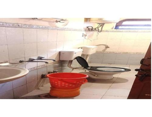 a bathroom with a toilet and a sink and a bucket at Hotel Narmada Bhawan, Badrinath in Badrīnāth