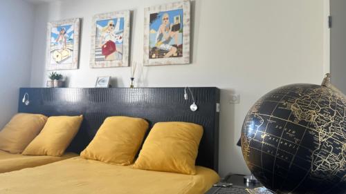 a bed with yellow pillows and a black head board at Domaine Georges V in Saint-Junien